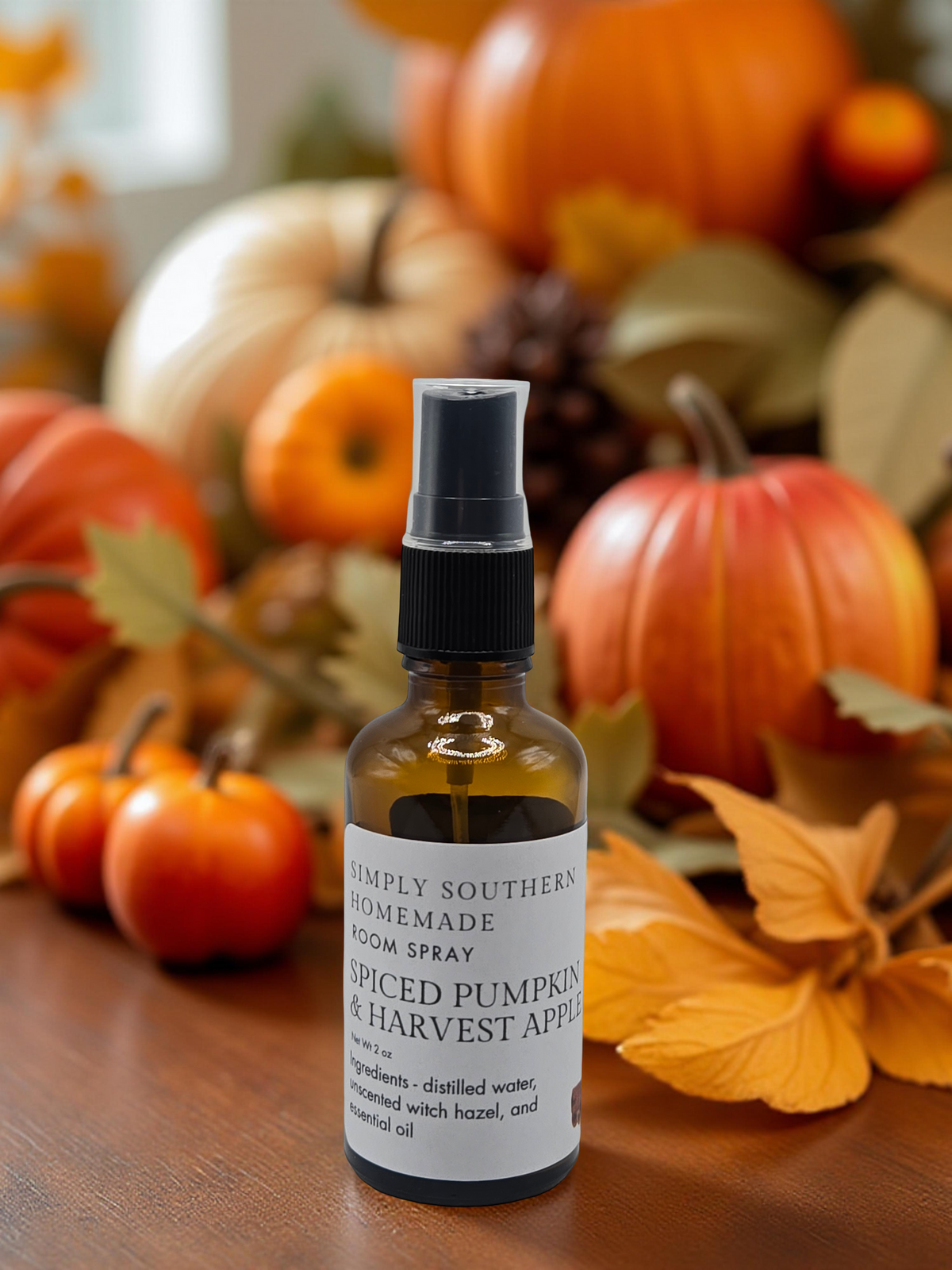 Spiced Pumpkin and Harvest Apple room spray among pumpkins, mini apples and autumn leaves
