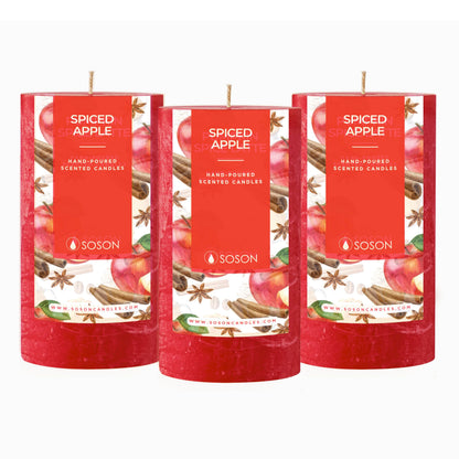 Set of 3 red Spiced Apple scented pillar candles on white