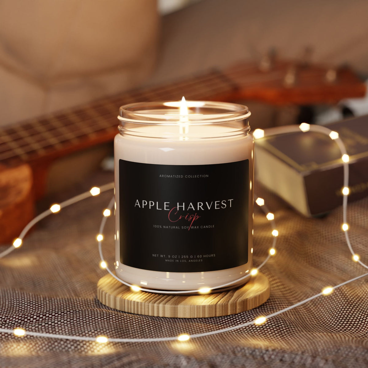 Lit Apple Harvest Crisp candle surrounded by fairy lights