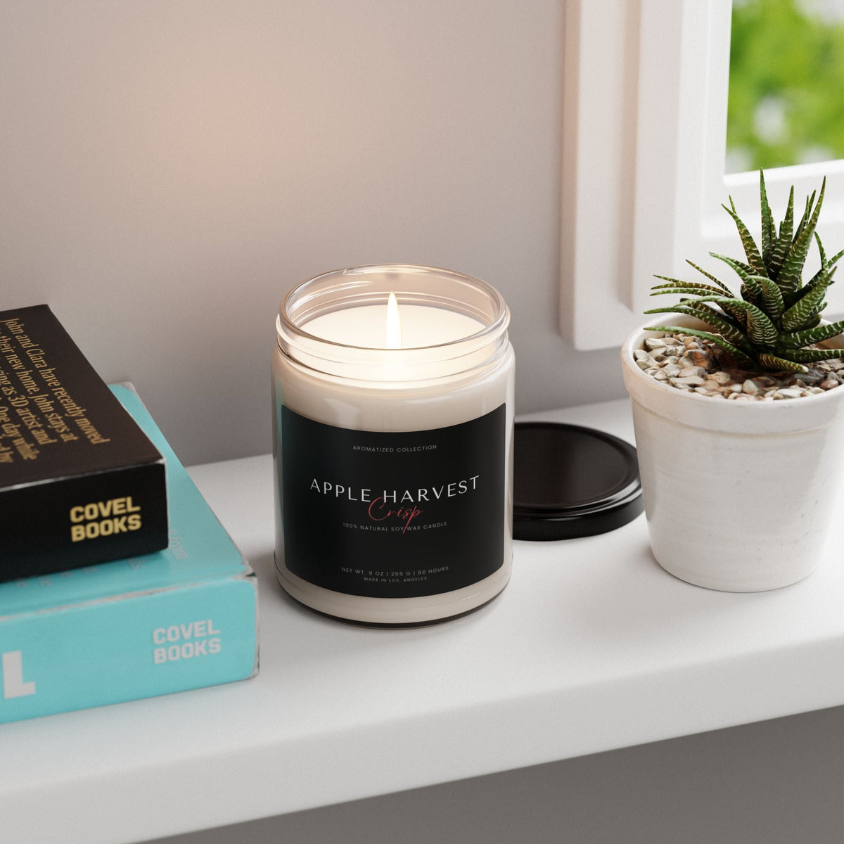 Apple Harvest Crisp candle on a windowsill with books and a succulent
