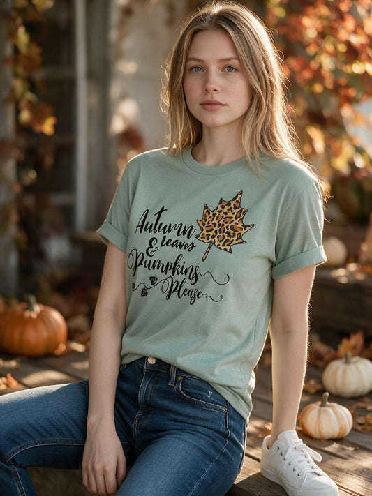 Woman wearing the sage Autumn Leaves and Pumpkins Please t-shirt with jeans on an autumn porch