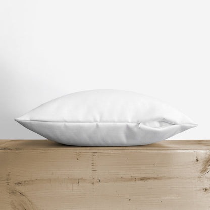 Side view showing the thickness of the Blessed throw pillow on a wooden shelf