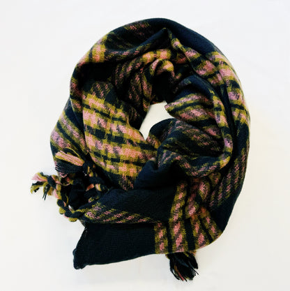Black and pink plaid scarf with braided fringe, loosely folded on white
