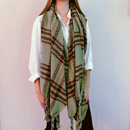 Sage green braided fringe plaid scarf worn long over a white shirt