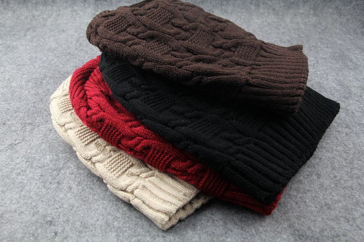 Stack of cable knit slouchy beanies in brown, black, red and beige