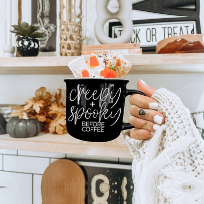 Creepy and Spooky mug with candy corn treats held by a hand in a cream knit sleeve