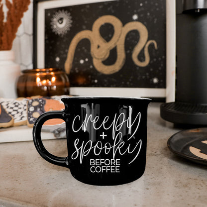 Black Creepy and Spooky Before Coffee mug on a kitchen counter with Halloween art