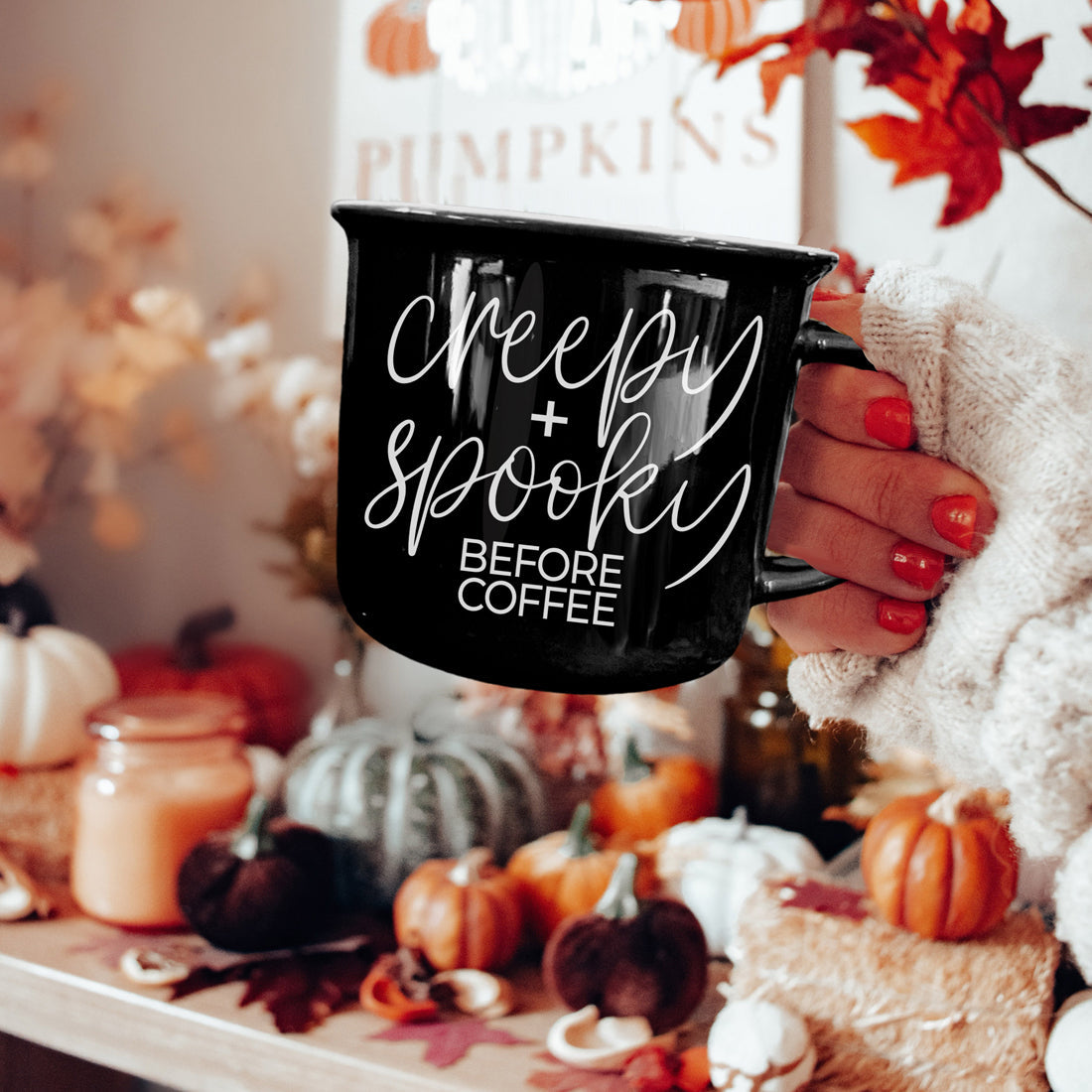 Creepy and Spooky mug held over a fall table with pumpkins and candles