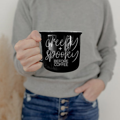 Creepy and Spooky mug held by a woman in a gray sweatshirt