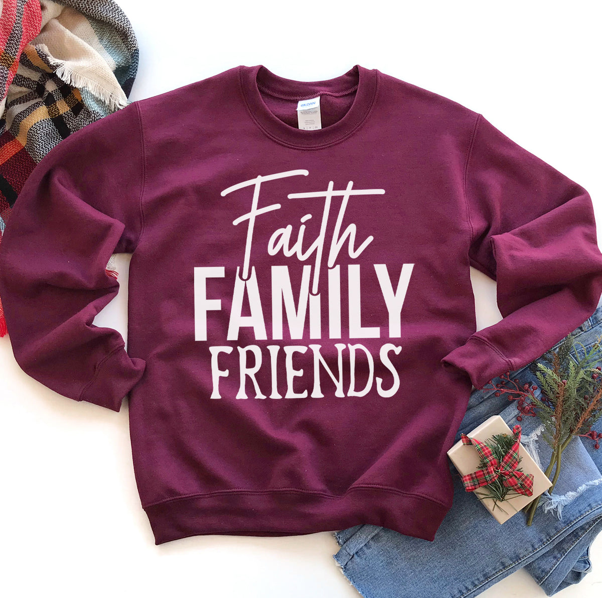 Maroon Faith Family Friends sweatshirt flat lay with a plaid scarf
