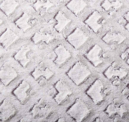 Close-up of the embossed geometric pattern on the white and purple faux fur throw