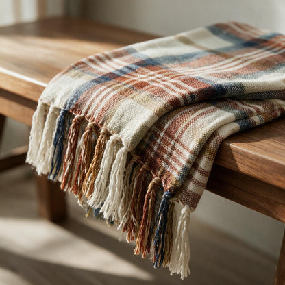 Close-up of the rust, cream and navy harvest plaid weave and twisted tassel fringe