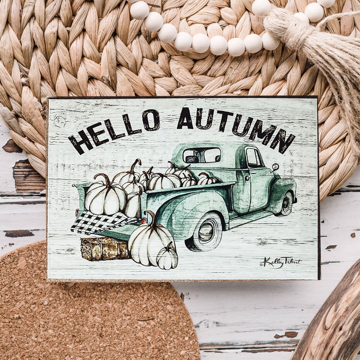 Hello Autumn sign with a teal vintage truck and pumpkins on wicker and cork