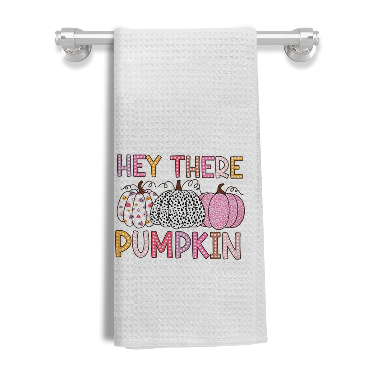 White waffle kitchen towel with Hey There Pumpkin print hanging on a towel bar