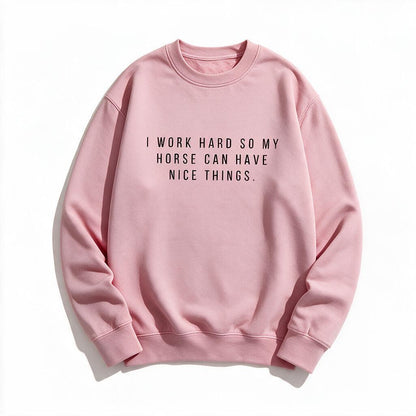 I Work Hard So My Horse Can Have Nice Things sweatshirt in light pink, flat lay on white