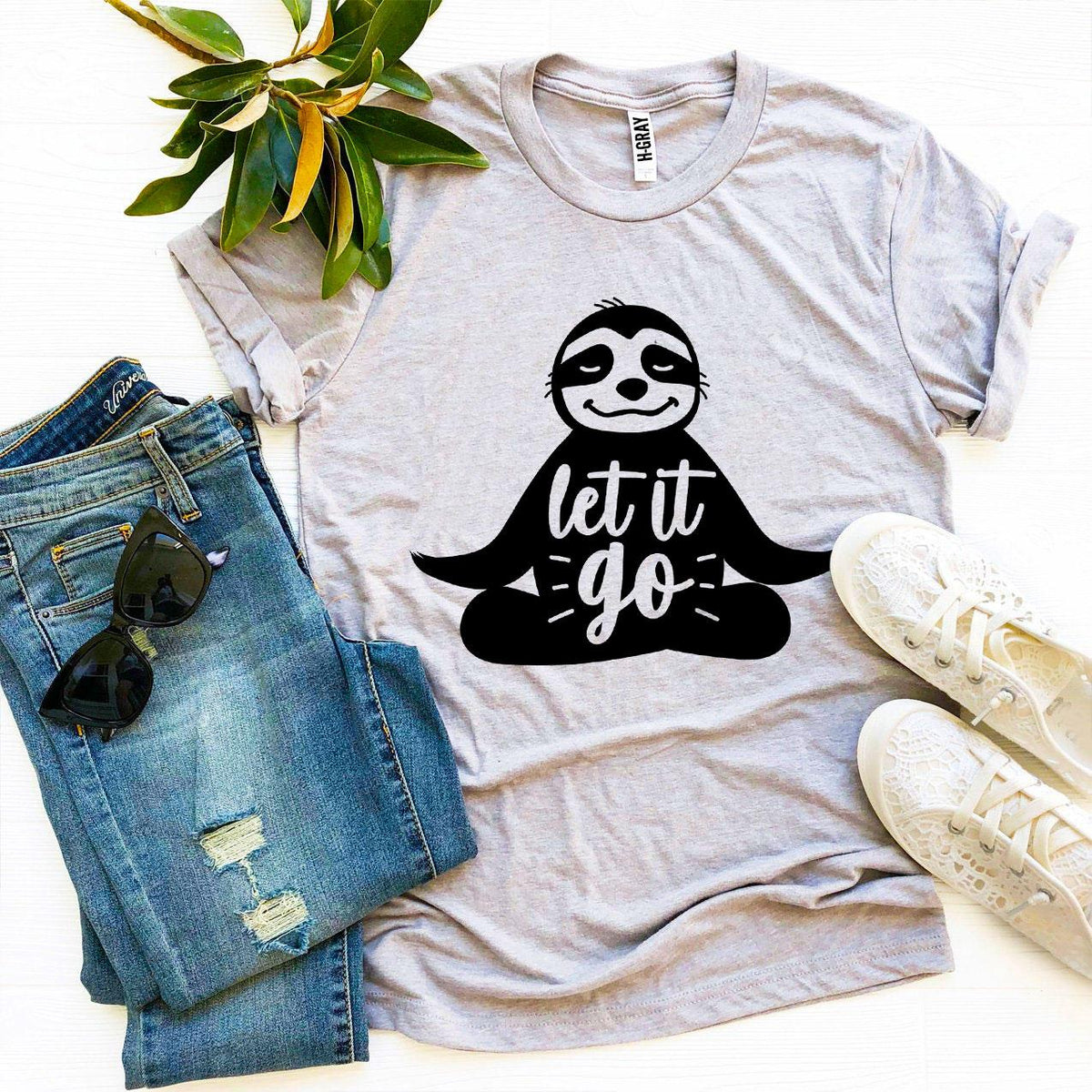 Light gray Let It Go sloth t-shirt flat lay with jeans and sneakers