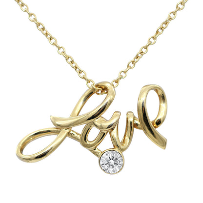 Gold-plated Love script pendant with a round white crystal on its chain, on white