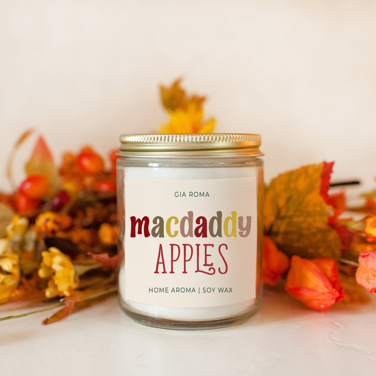 Macdaddy Apples soy candle jar with autumn leaves and berries