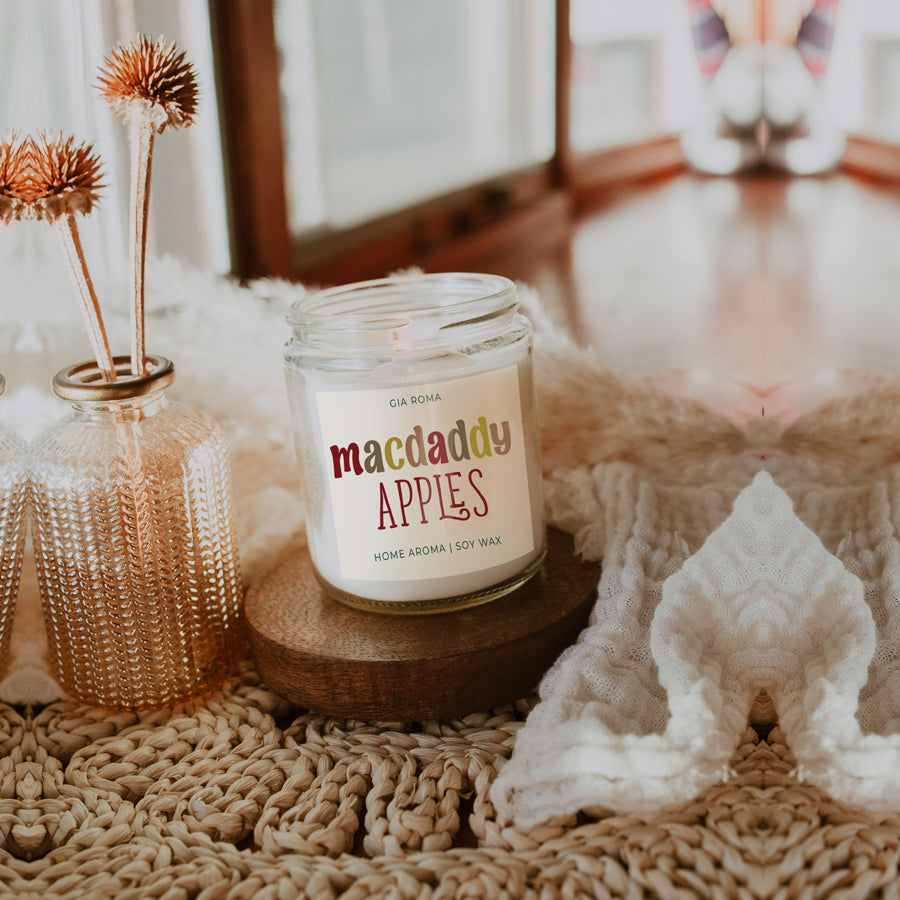 Macdaddy Apples soy candle on a wood slice with dried flowers