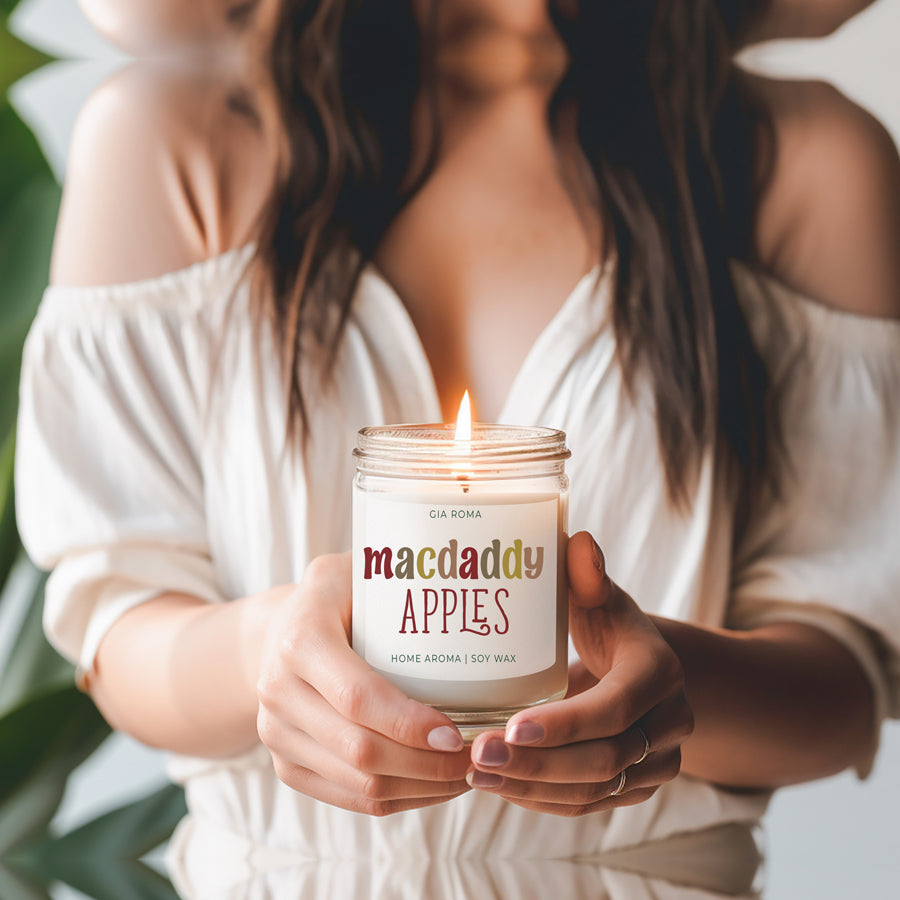 Woman holding the lit Macdaddy Apples soy candle