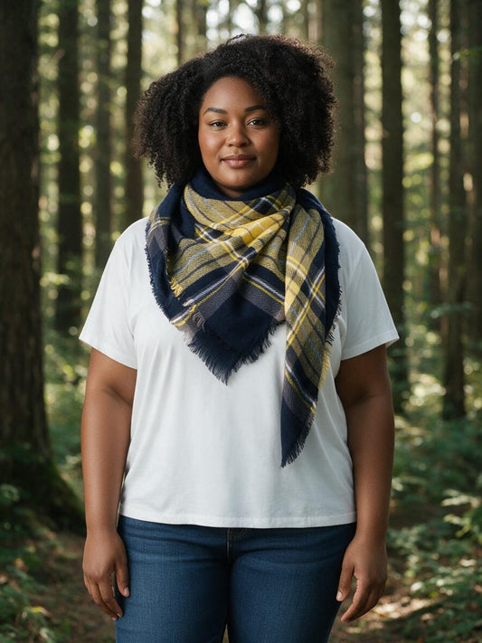 Woman wearing the navy and yellow tartan blanket scarf in a forest