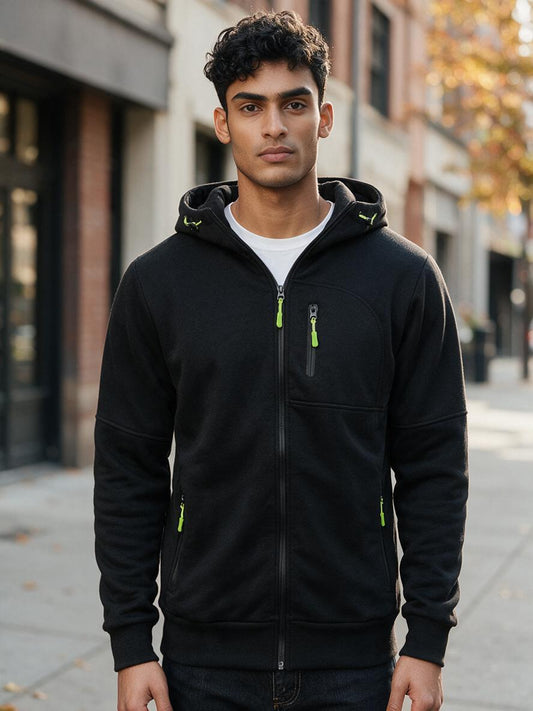 Man wearing the black hooded fleece jacket with green zippers on an autumn city street