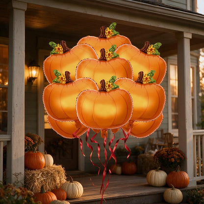 Pumpkin foil balloons floating above a fall-decorated front porch