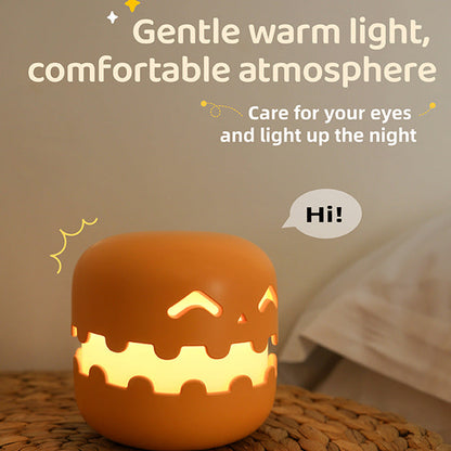Orange pumpkin night light glowing with a soft warm light on a bedside table