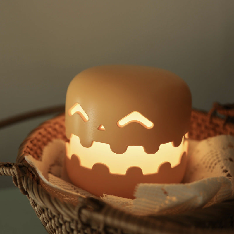 Smiling pumpkin silicone night light glowing in a woven basket