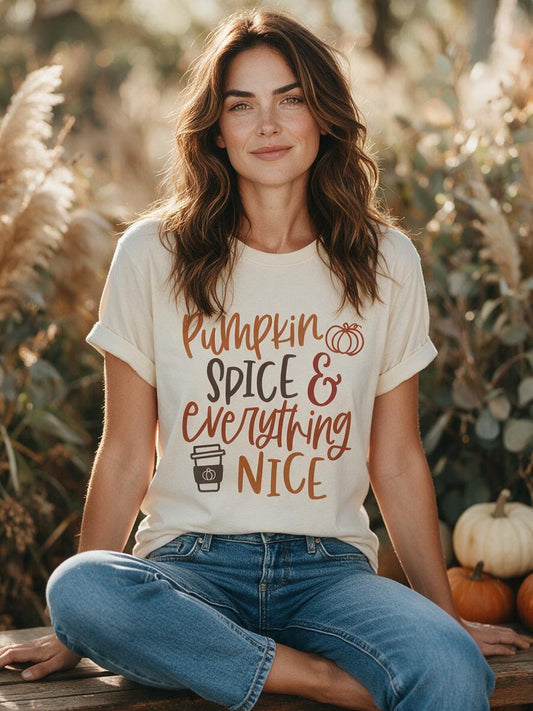Woman wearing the cream Pumpkin Spice and Everything Nice t-shirt sitting outdoors in autumn