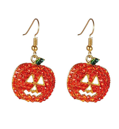 Pair of red-orange rhinestone jack-o-lantern dangle earrings with gold-tone hooks on a white background
