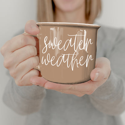 Hands holding the tan Sweater Weather coffee mug
