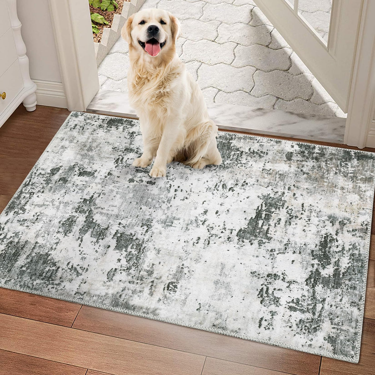 Grey, white and sage abstract washable rug in a tiled entryway with a golden retriever sitting on it