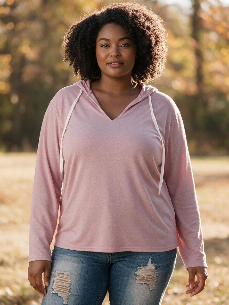 Woman wearing the pink v-neck hooded pullover with jeans in autumn light