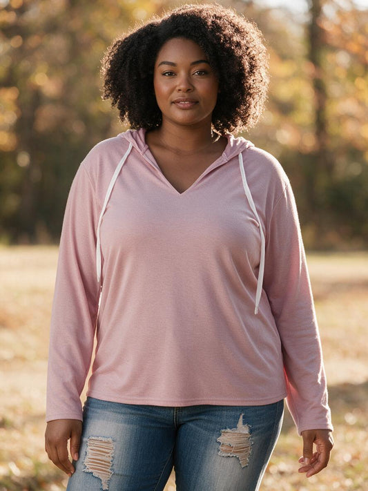 Woman wearing the pink v-neck hooded pullover with jeans in autumn light